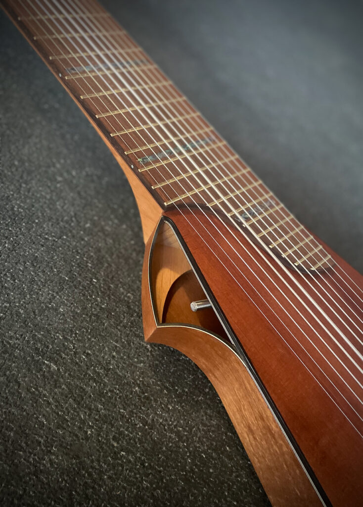 A view of the sound port and body of Dragonfly Tapping Instruments nylon string acoustic model ... a unique acoustic instrument for tapping/touchstyle technique. The K&K Trinity condenser mic can be seen