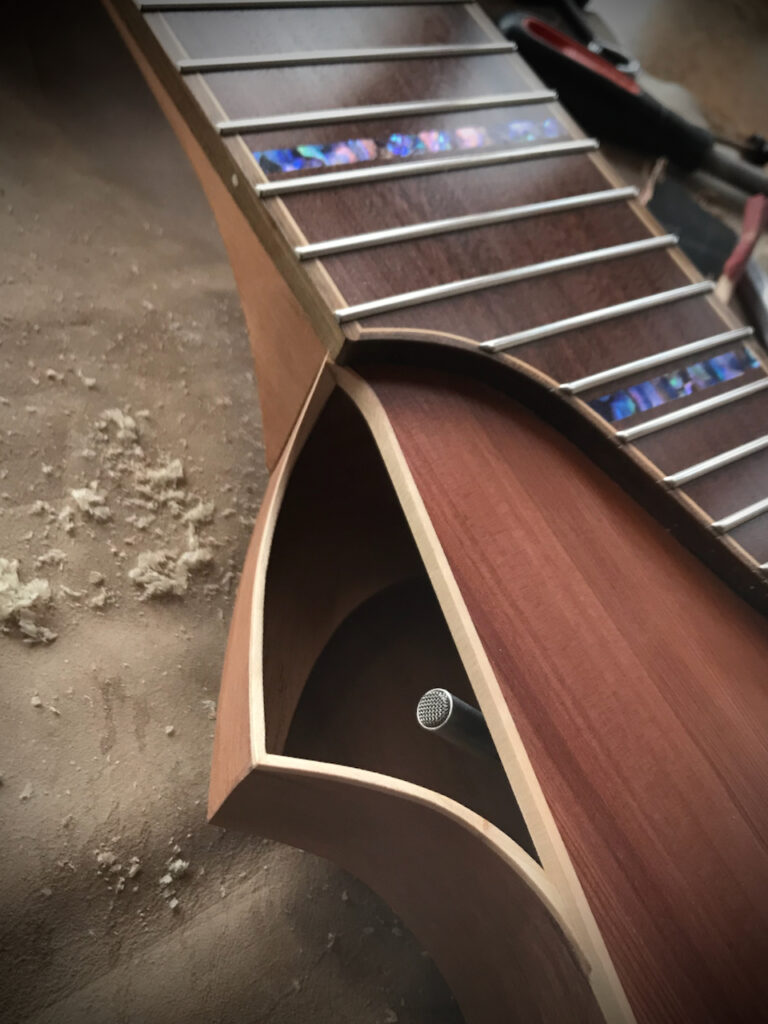 A close up view of the sound port of Dragonfly Tapping Instruments nylon string acoustic model ... a unique nylon string instrument for tapping/touchstyle technique. The K&K Trinity condenser mic can be seen